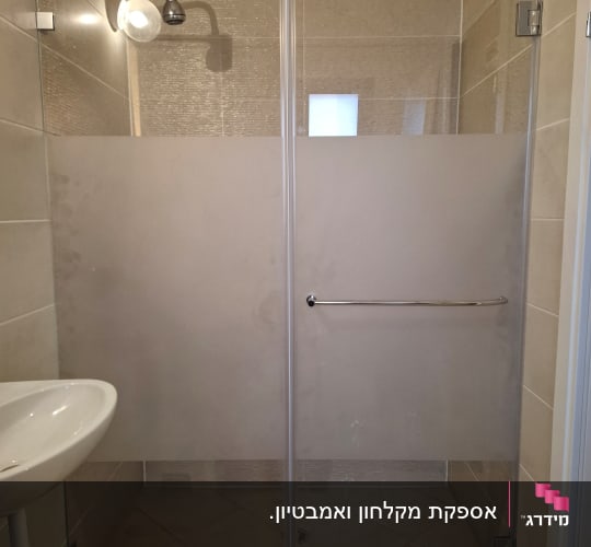 מקלחון חזית מזכוכית עם פס חלבי בחדר רחצה